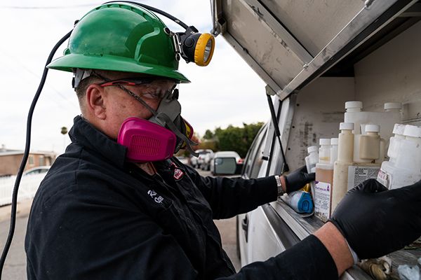pest control looking at chemicals in a truck  